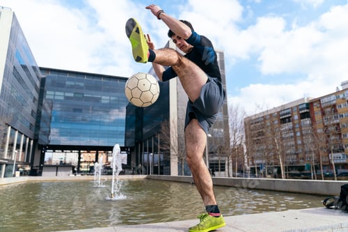 Preview: Freestyle soccer player juggling ball outdoors in city