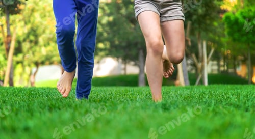 Preview: Children's feet go on the grass. Selective focus.