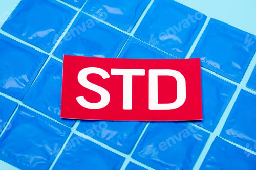 Preview: top view of red paper with std lettering on packs with condoms isolated on blue