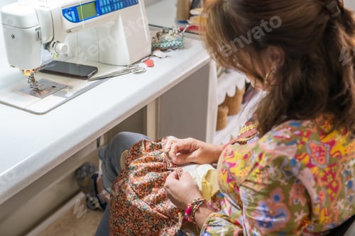 Preview: Seamstress sewing fabric by hand in workshop