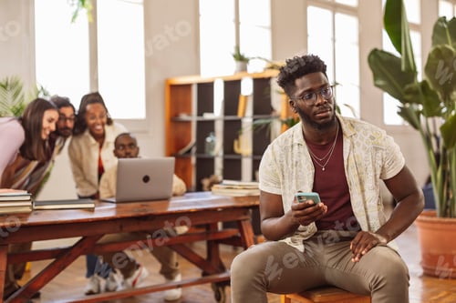 Preview: black boy sitting with thoughtful look while his friends in the background looking