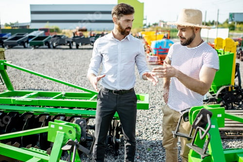 Preview: Agronomist with salesman at the shop with agricultural machinery