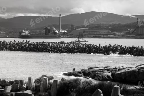 Preview: Factory near Galician cliffs with sea barriers, perfect for travel and industrial themes.