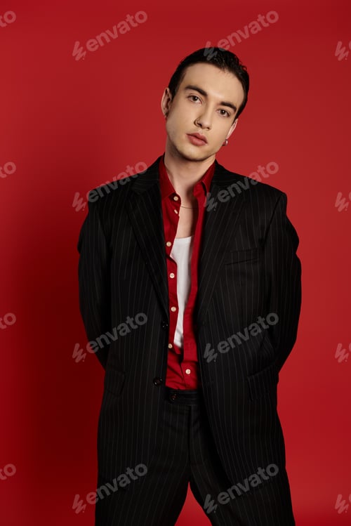 Preview: Sophisticated Man in Black Suit Posing Against Vibrant Red Background