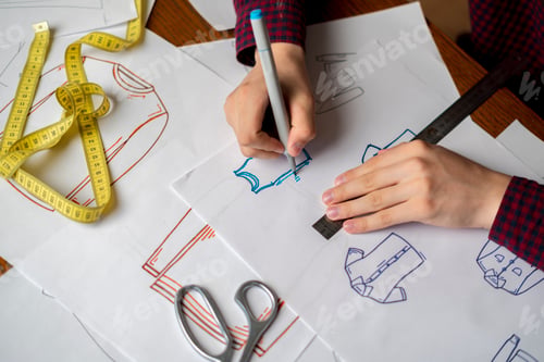 Preview: designer drawing new fashion wear on paper b