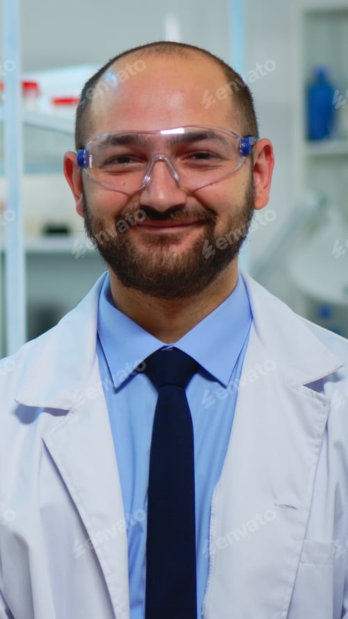 Preview: Portrait of scientist man smiling at camera sitting in modern laboratory