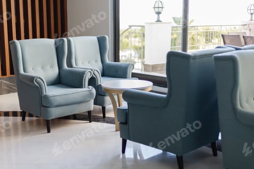 Preview: Two stylish blue armchairs sit next to a small round table, creating a cozy seating area