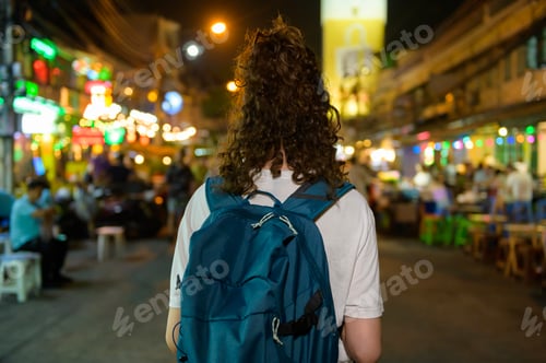 Preview: Tourist woman on vacation exploring at Khao San road at night in Bangkok