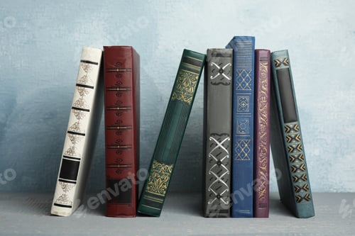 Preview: Collection of old books on grey wooden shelf
