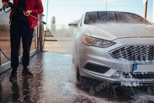 Preview: a man washes a car with a pistol at a self-service car wash