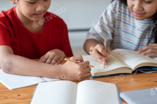 Preview: Close-up of Asian man and woman students brainstorming together at the classroom. Taking note.