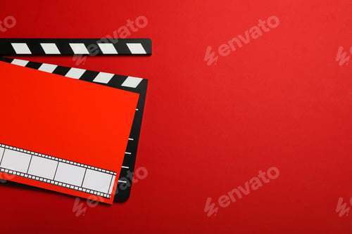 Preview: Clapperboard and red paper with film on red background, space for text
