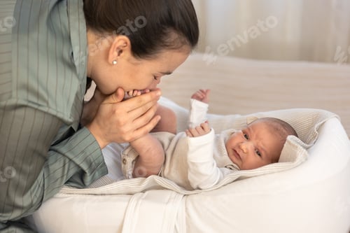 Preview: Mother kissing baby daughter. Newborn baby. Motherhood.