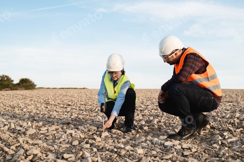 Preview: Survey engineers working at construction land site - Topographic work concept - Focus on woman face