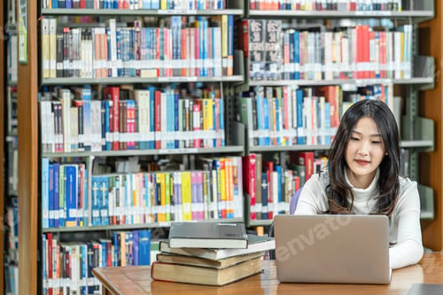 Preview: Asian young Student in casual suit doing homework and using technology laptop in library