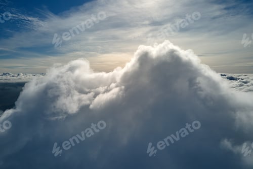Preview: Aerial view from airplane window at high altitude of earth covered with white puffy cumulus clouds