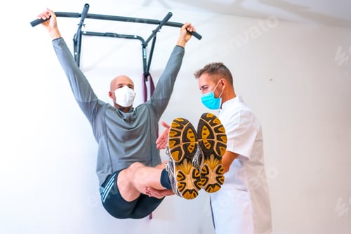 Preview: Healthcare professional guiding the patient at the rehabilitation gym with masks on
