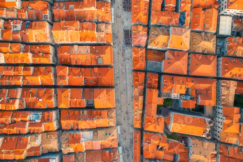 Preview: Aerial view of houses with orange roofs at sunset in summer