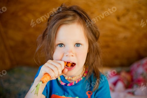 Preview: Little girl eats a carrot