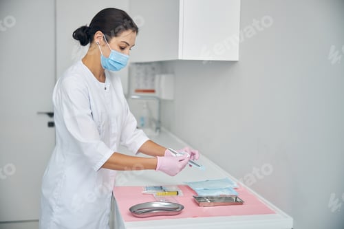 Preview: Female dermatologist unpacking a sealed biopsy tool