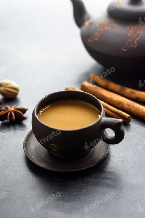 Preview: Masala tea in a clay mug and teapot. Traditional Indian hot drink