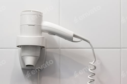 Preview: White hair dryer on the wall in bathroom with white tiles