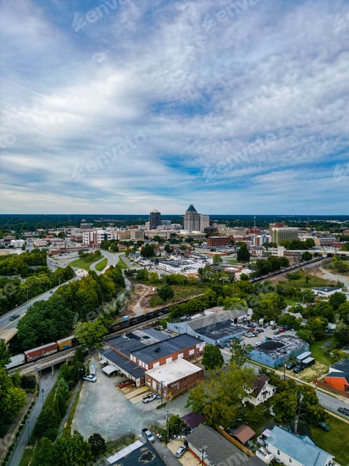 Preview: Vertical shot of the cityscape in Greensboro with buildings surrounded by green trees