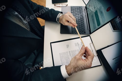 Preview: Businessman Examining CV At Interview