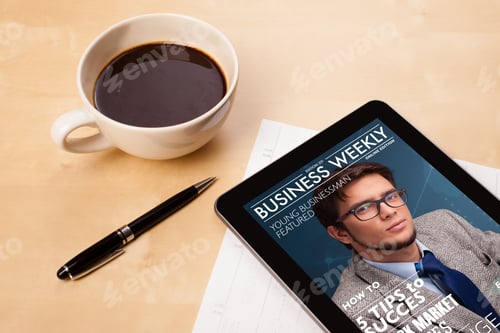 Preview: Workplace With Tablet Pc Showing Magazine Cover And A Cup Of Coffee On A Wooden Work Table Close-Up