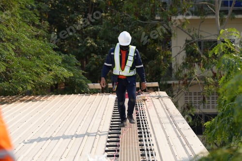 Preview: Engineer installing solar cell panels on roof.