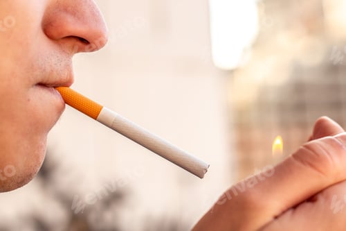 Preview: Smoking concept. Man lighting a cigarette with a lighter. Smoking a cigarette close-up.