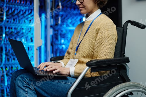 Preview: Woman with disability using laptop in server room
