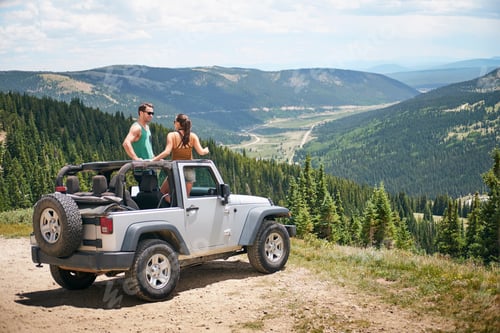 Preview: Road trip couple in parked four wheel convertible in Rocky mountains, Breckenridge, Colorado, USA