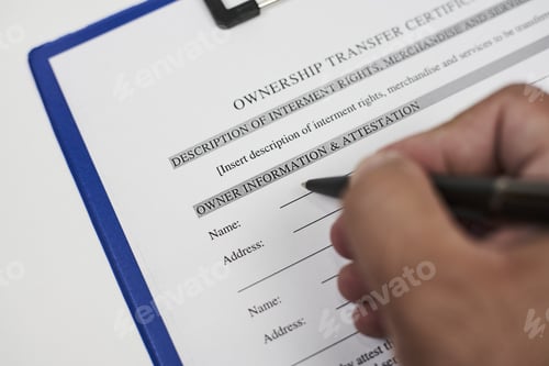 Preview: Closeup shot of a person filling in an ownership transfer application with a black pen