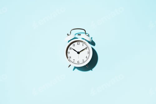 Preview: White alarm clock with hard shadow on blue background. Top view