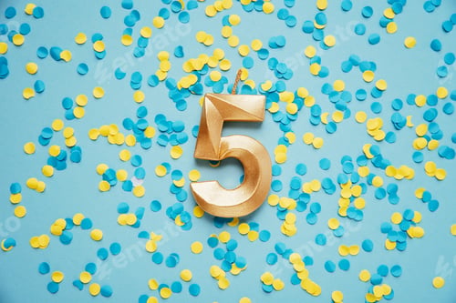 Preview: Number 5 five golden celebration birthday candle on yellow and blue confetti Background.