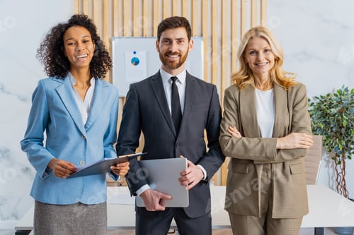 Preview: Group of multiethnic businesspeople standing at computer desk in the office