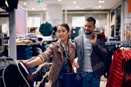 Preview: Young woman and her boyfriend shopping at clothing store.