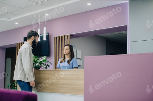Preview: Male patient interacting with healthcare clinic receptionist