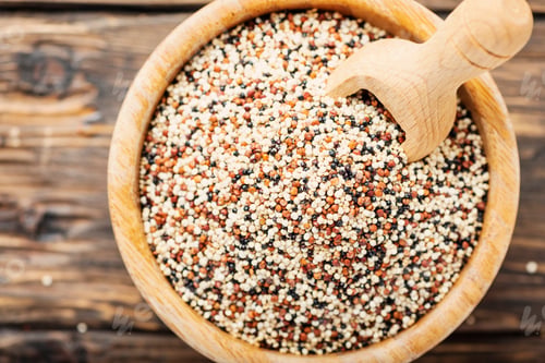 Quinoa Seeds in Bowl with Wooden Spoon