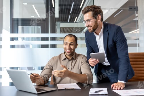 Preview: Two colleagues collaborating over a laptop in an office environment