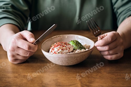 Preview: Woman eating vegetarian salad in cafe. Healthy bowl with buckwheat, poached egg and avocado sauce
