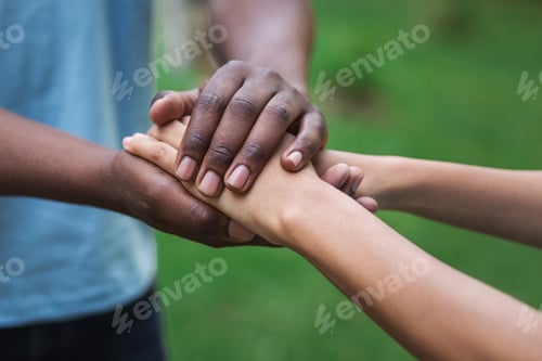 Preview: Black caregiver supporting woman hand in park