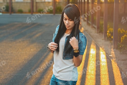 Preview: Beautiful girl in a denim jacket in the sunlight sunset.