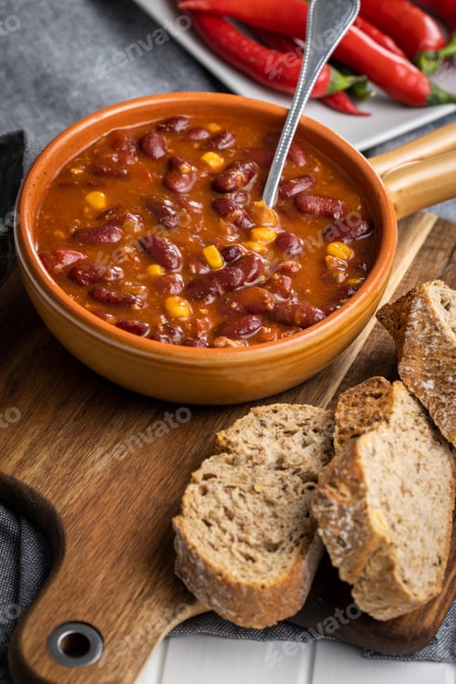 Preview: Chili con carne. Mexican food with beans in pot and bread