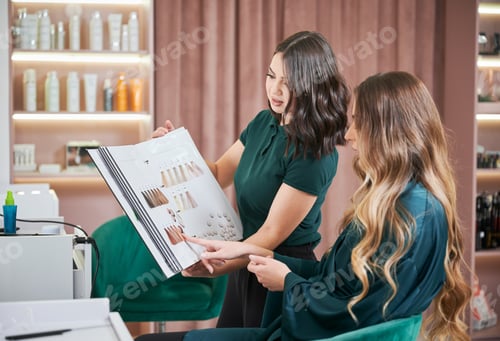 Preview: Woman and hairdresser choosing hair color in beauty salon.