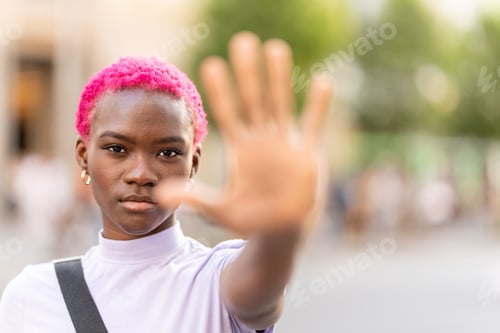 Preview: Stylish african woman raising the hand to represent stop in the street