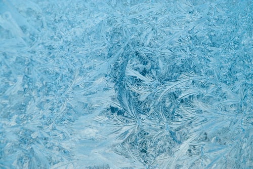 Preview: Frosty patterns on glass. Christmas background. Blue ice on winter window.