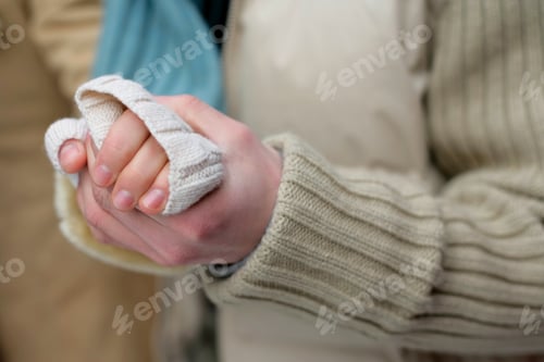 Preview: Closeup of two people holding hands in a tender gesture