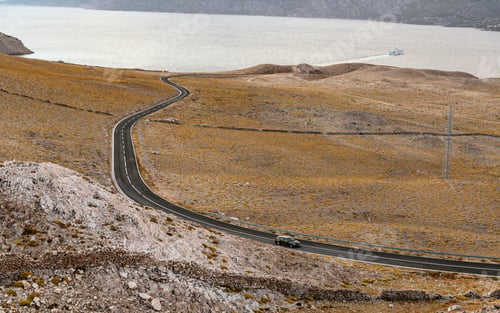 Preview: High angle view of scenic road through Arid landscape by sea on Pag island in Croatia.